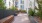 a wooden deck with plants and a building in the background