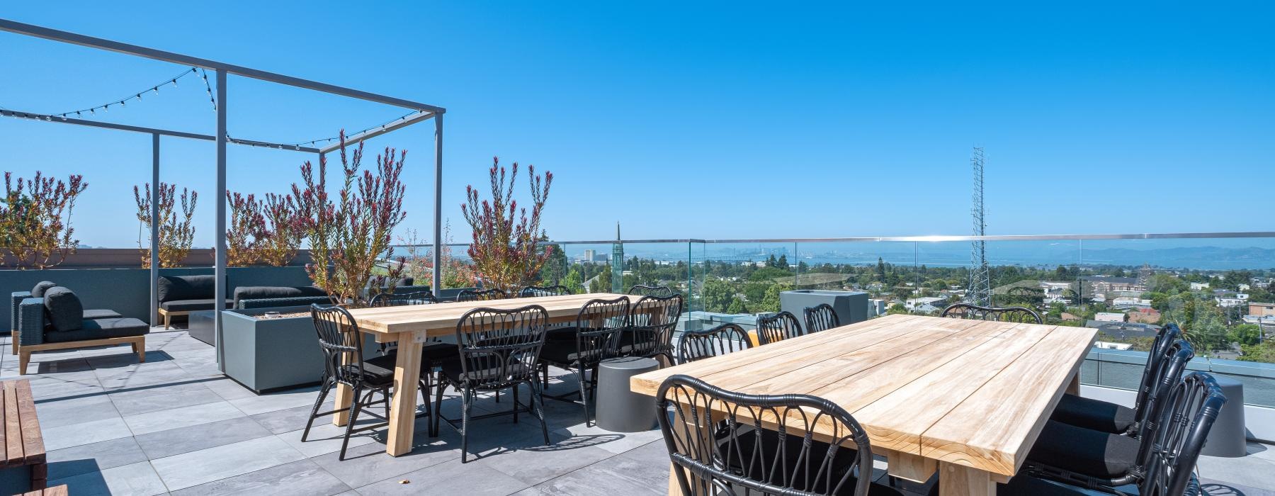 a patio with tables and chairs on it with a view of the city in the background